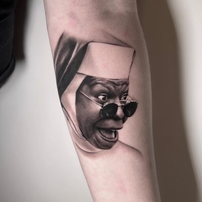 Tatouage de Whoopi Goldberg en Sœur Mary Clarence en noir et gris.